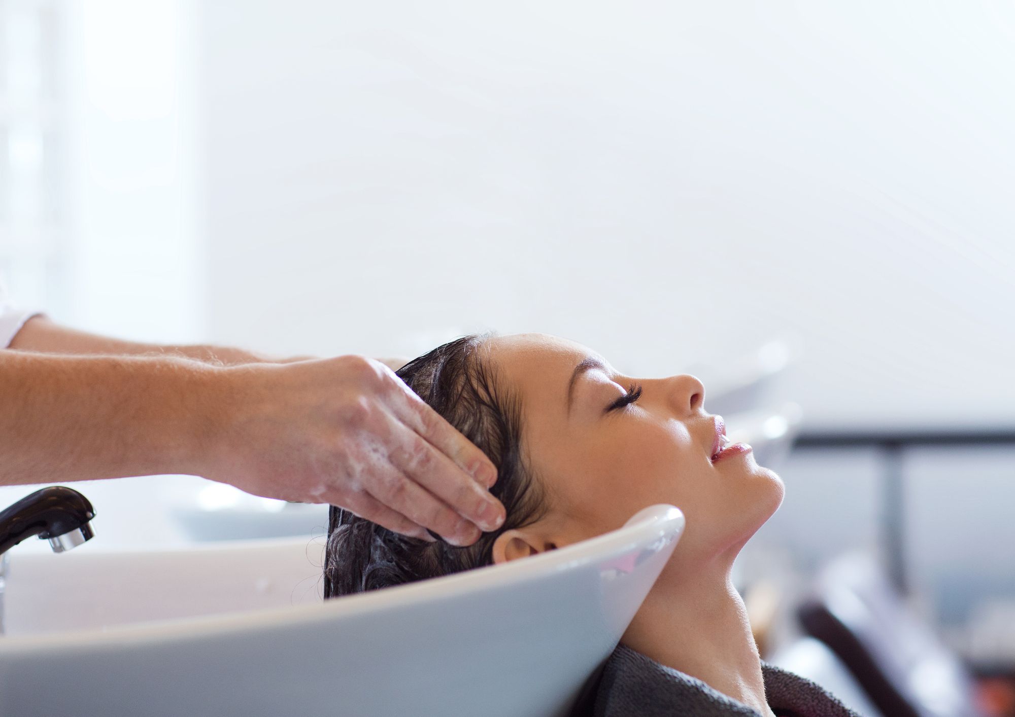 Lavando el pelo a una clienta que se hará las mechas balayage